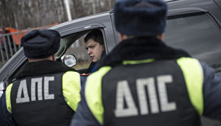 Сотрудники ГИБДД проверяют документы у водителя в рамках рейда скрытых патрулей ДПС в Москве